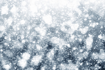 Snowflakes particles and bokeh or glitter lights on silver background. Christmas abstract template