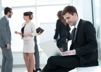 communication concept:businessman working with laptop on the kne