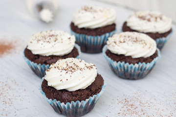 Chocolate cupcakes on white wood background, copy space