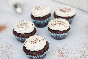 Chocolate cupcakes on white wood background, copy space