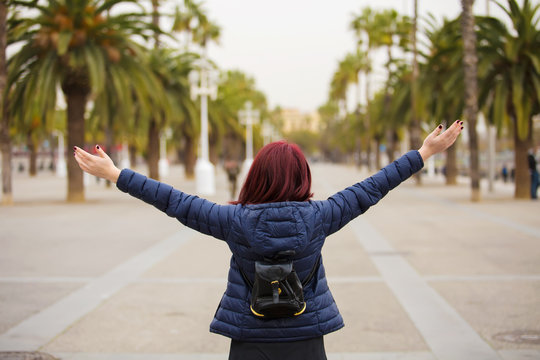 Freedom-Young woman with raised hands in a city.Young tourist woman walking with raised hands feeling free in Barcelona.Life style