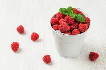 Raspberry in white mini bucket with fresh mint leaves
