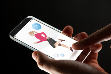close up of hands with fitness app on smartphone