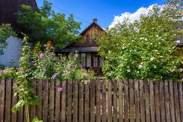 Fototapeta na wymiar Old wooden house with fence and summer flowers in city of Kazimierz Dolny. Poland.