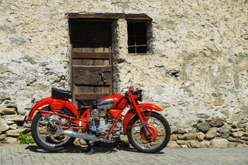 Fototapeta na wymiar Red bike parked on the street of old town in Italy