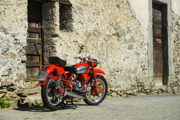 Fototapeta na wymiar Red bike parked on the street of old town in Italy