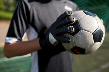 close up of goalkeeper with ball playing football