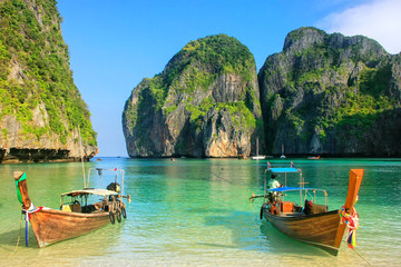 Naklejka premium Longtail łodzie zakotwiczali przy majowie zatoką na Phi Phi Leh wyspie, Krabi prowincja, Tajlandia