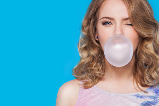 young pretty teenager girl emotional posing on blue background, fashion lifestyle people concept