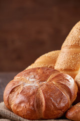 Assortment of baked bread on wooden table background