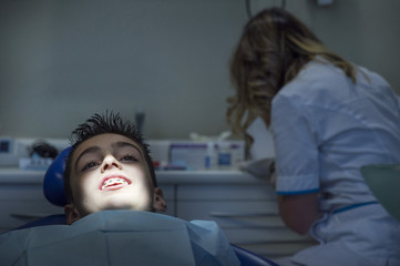 Dentists with a patient during a dental intervention to boy