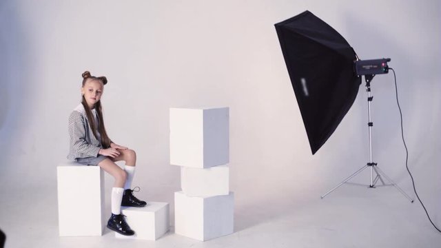 Young girl posing in studio with white background