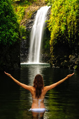 Young woman in bikini standing at Wainibau Waterfall on Taveuni Island, Fiji