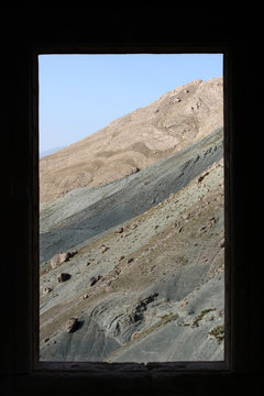 Fototapeta Blick durch das Fenster eines historischen Gebäudes auf einen kahlen steinigen Berghang in Kurdistan, Anatolien, Türkei