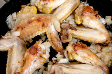 Fried chicken wings in a frying pan