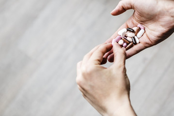 young addicted woman is deciding which pill of drug to eat