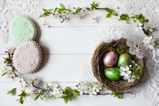 Easter background with a nest, eggs, gingerbread and branch with flowers