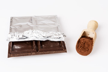 wooden spoon with coacoa or cacao and chocolate on white
