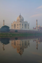 Fototapeta na wymiar View of Taj Mahal with early morning fog reflected in Yamuna River, Agra, Uttar Pradesh, India