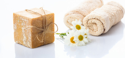Handmade soap bar and chamomile on white background