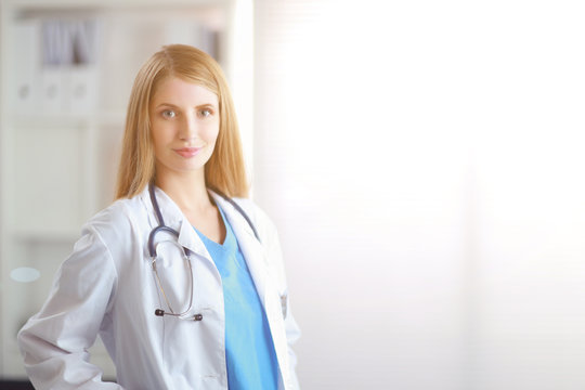 Doctor woman is standing in the near window
