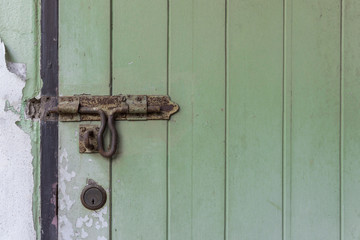 Aged door bolt on green door