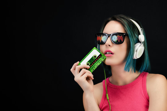 Jeune femme tenant dans sa main une cassette audio