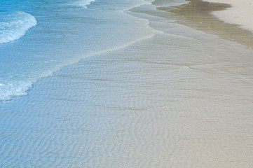 Blue ocean water with white wave on beach