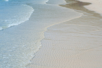 Blue ocean water with white wave on beach