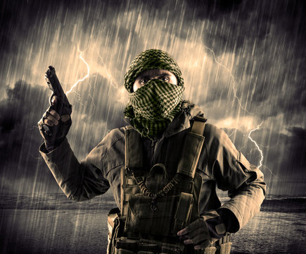 Dangerous armed terrorist with mask and gun in a thunderstorm with lightning