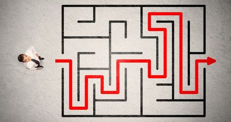 Lost businessman found the way in maze with red arrow