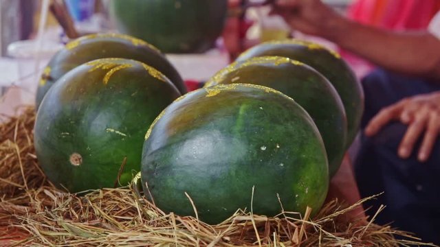 Man Paints Watermelon with Brush at Market in Vietnam