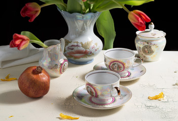 Tea cups and flowers on antique table