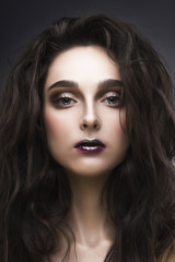 Fototapeta premium beauty portrait of the young woman in a with a vanguard make-up and a flowing hair on a gray background