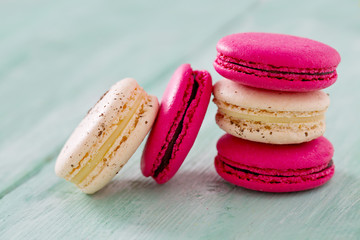 raspberry and vanilla macaroons on turquoise wooden surface