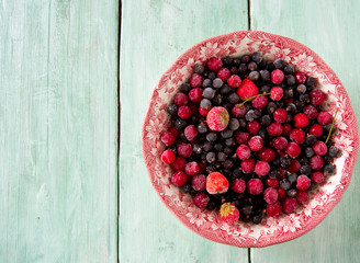 frozen summer berries on wooden surface
