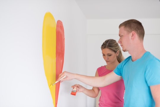 couple are painting a heart on the wall