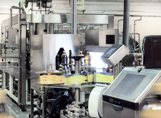 The filling machine pours beer into plastic PET bottles.