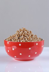 Buckwheat porridge with butter in a red bowl in polka dots 