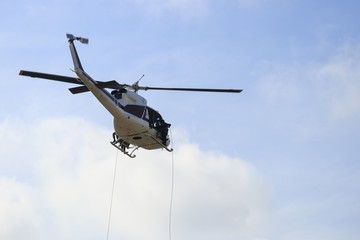 Soldier rappelling from helicopter in blue sky with blur propeller
