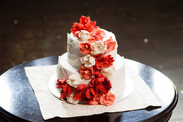Red and white wedding cake with roses.