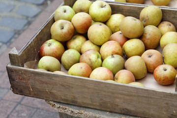 Red and green apples in a box made of wood