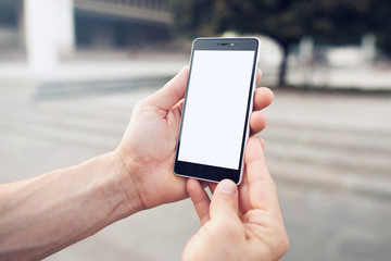 Searching for location with online smartphone maps. Hands holding blank screen smartphone with clipping path for screen