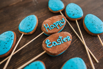 Obraz na płótnie Canvas Happy easter sweets and desserts decoration. Blue cake pops with lettering on the wood rustic table for easter celebration, closeup.