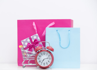 cool shopping bags, gift in shopping cart and alarm clock on the wonderful white background