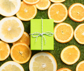 photo of cute gift near dried orange slices on the wonderful green grass background
