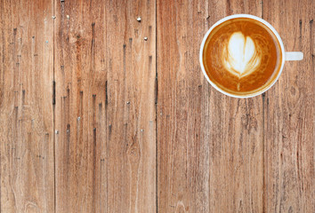 Fototapeta na wymiar Top view of a coffee with heart pattern in a white cup on wooden background, latte art