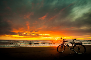 Fototapeta premium Tourist bike on the coast of the sea at sunset time