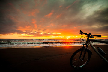 Fototapeta premium Tourist bike on the coast of the sea at sunset time