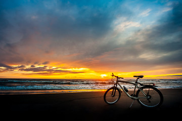 Fototapeta premium Tourist bike on the coast of the sea at sunset time